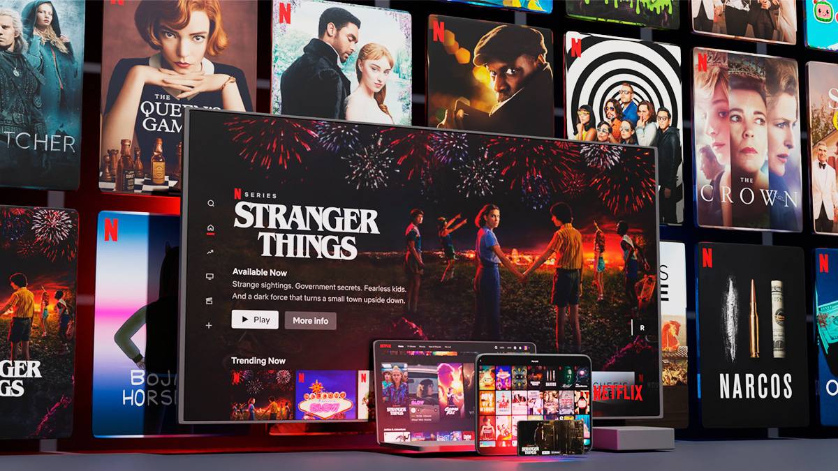 Netflix em telão, TV, tablet, celular e notebook com pôsteres de suas produções ao fundo