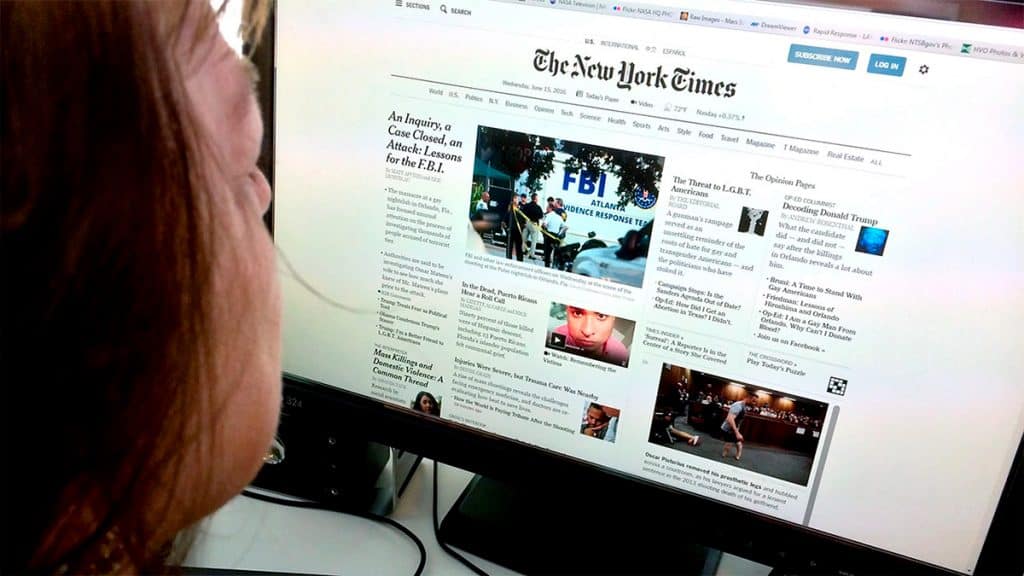 Pessoa olhando para home do site do jornal The New York Times num computador