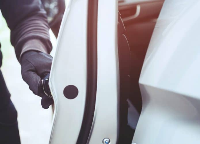 Ladrão de carros vestindo roupas pretas e luva