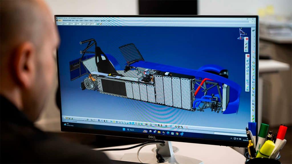Homem com projeto de veículo elétrico da Caterham aberto no computador