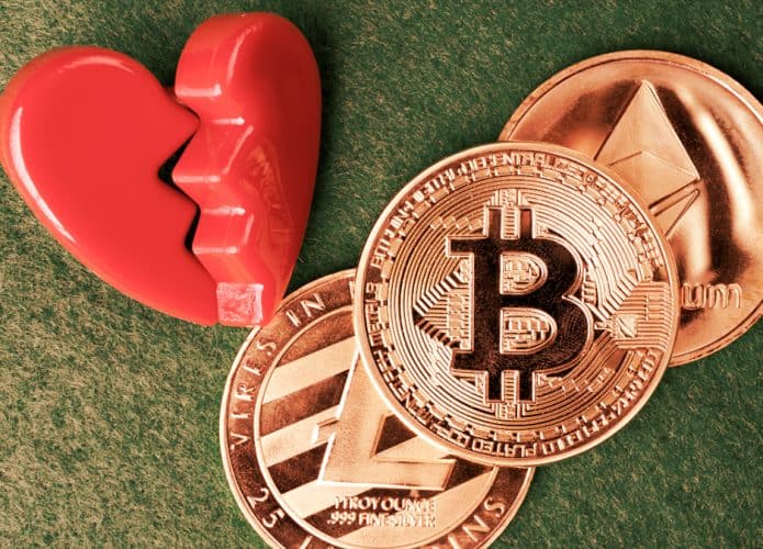 Montagem com coração partido, moeda de Bitcoin e de outras criptomoedas