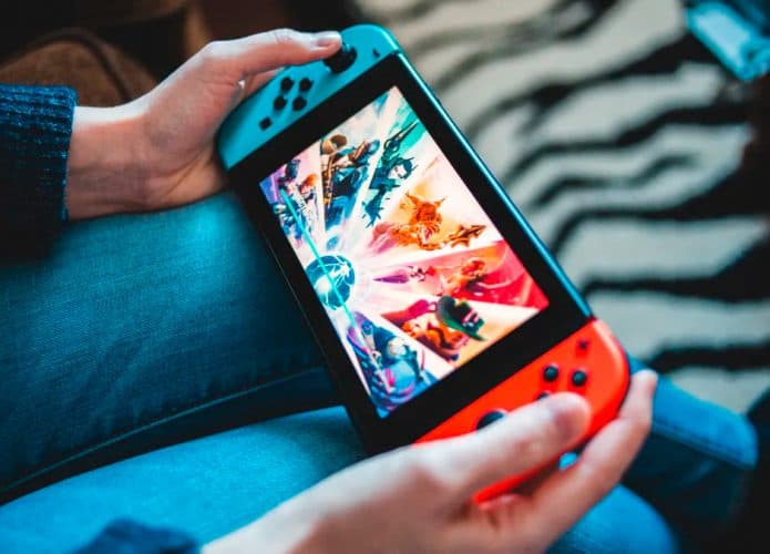 Pessoa jogando no Nintendo Switch com console apoiado no colo