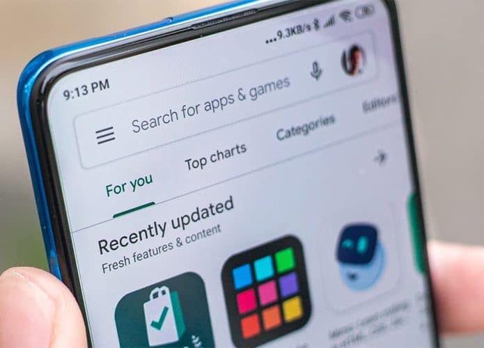 Pessoa segurando celular Android com Play Store aberta