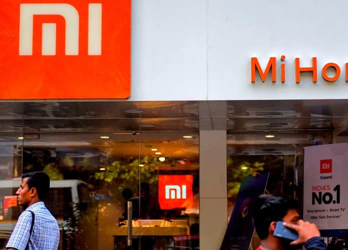 Fachada de loja da Xiaomi na Índia com homens passando na frente