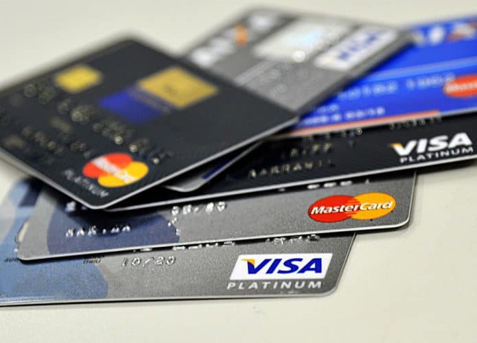 Cartões de crédito organizados em forma de leque sobre uma mesa