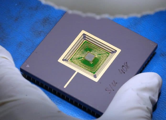 Funcionário manuseando, de luva, novo processador