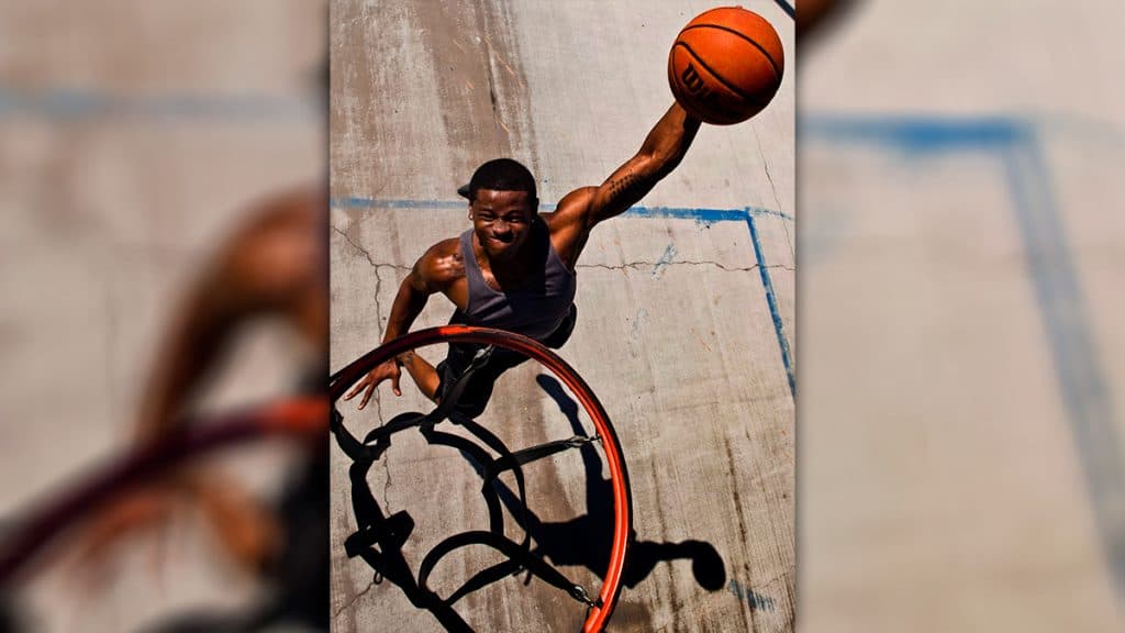 Jogador de basquete prestes a fazer enterrada na cesta