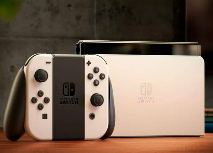 Controle de Nintendo Switch OLED encostado no console, ambos sobre uma mesa