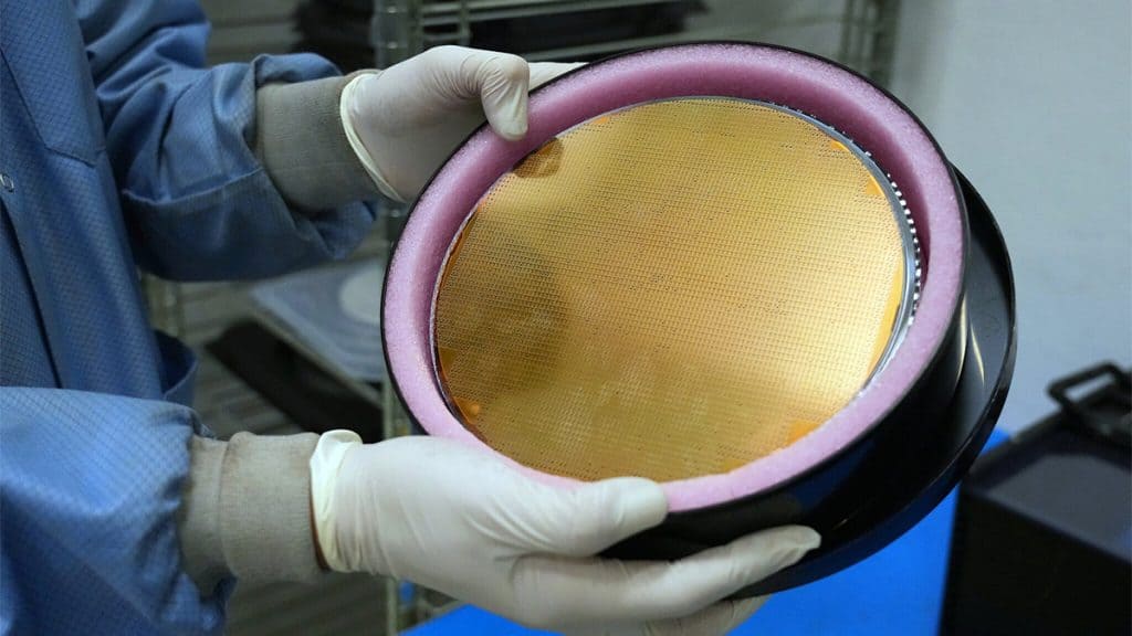 Funcionário manuseando waffer de silício na produção de novo processador
