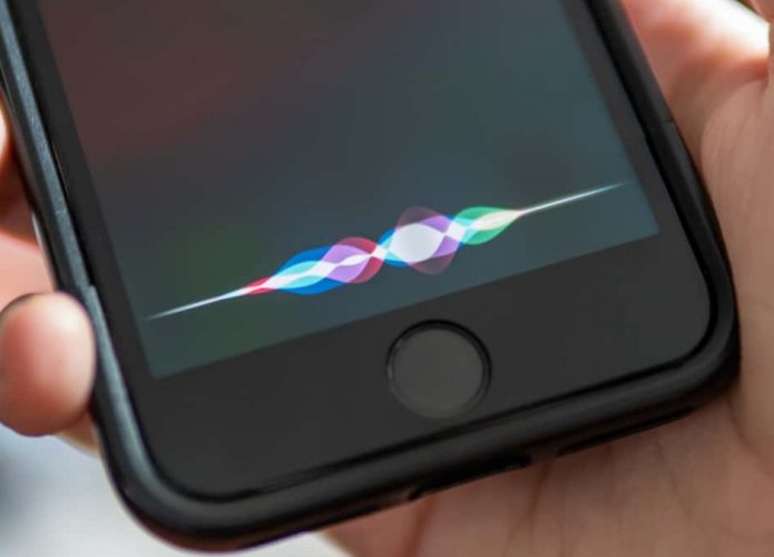 Pessoa segurando iPhone enquanto ativa a Siri