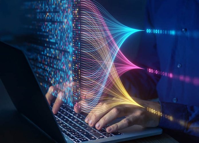 Pessoa digitando em notebook com desenho colorido de aprendizado de inteligência artificial em cima