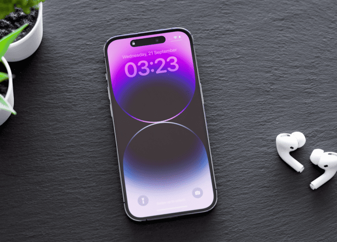 iPhone 14 Pro sobre uma mesa com par de AirPods do lado