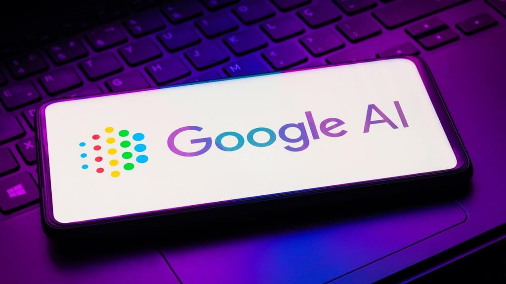 Smartphone com logomarca do Google AI aberta sobre teclado e trackpad de notebook iluminados por luzes coloridas