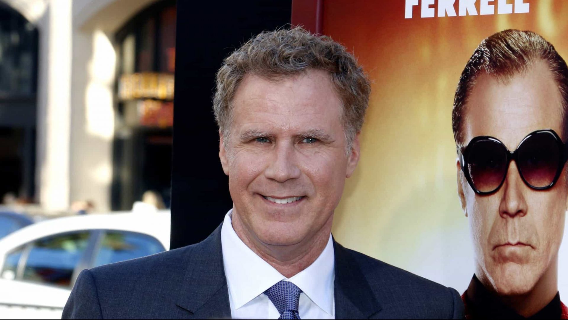Ator Will Ferrell em frente cartaz de produção em que estrela