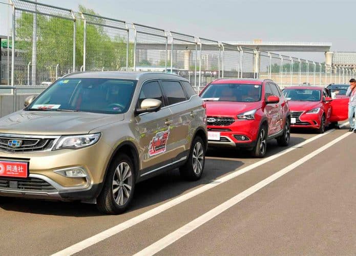 Fila de carros de montadoras chinesas em pista de teste num dia ensolarado