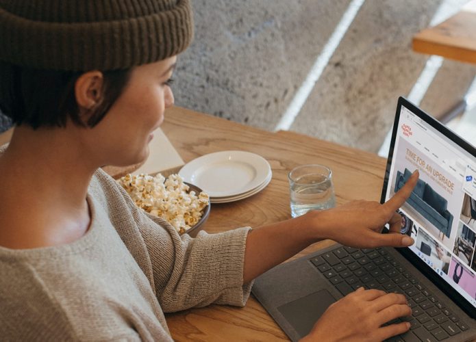 Mulher apontando para produto na tela do notebook