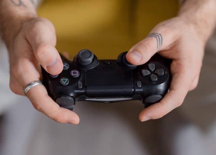 Homem segurando controle do PS4