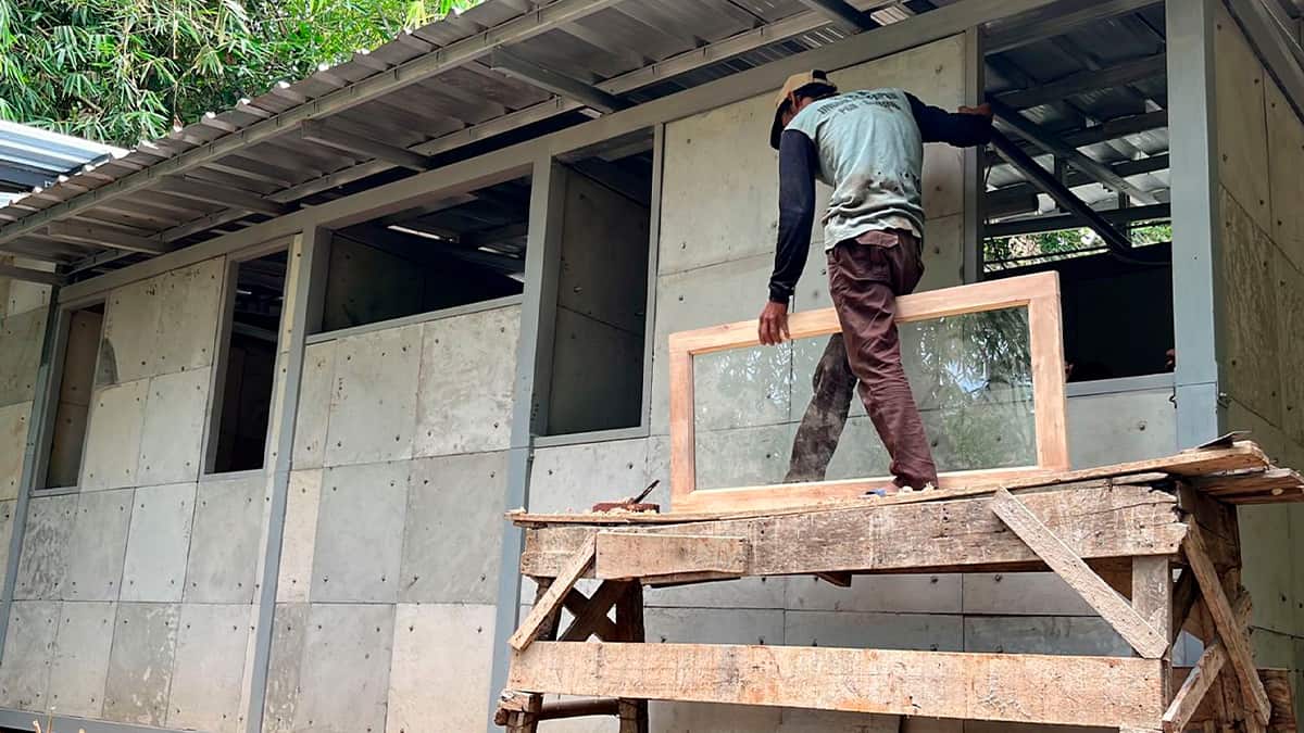 Homem trabalhando em construção de casa com concreto feito com fraldas usadas