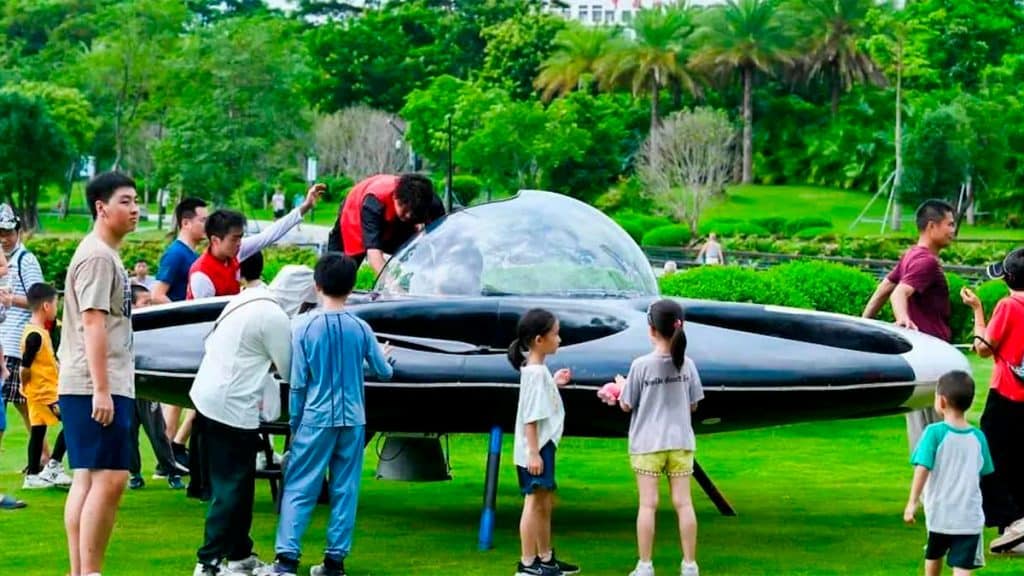 Pessoas em volta e em cima de disco voador elétrico na China