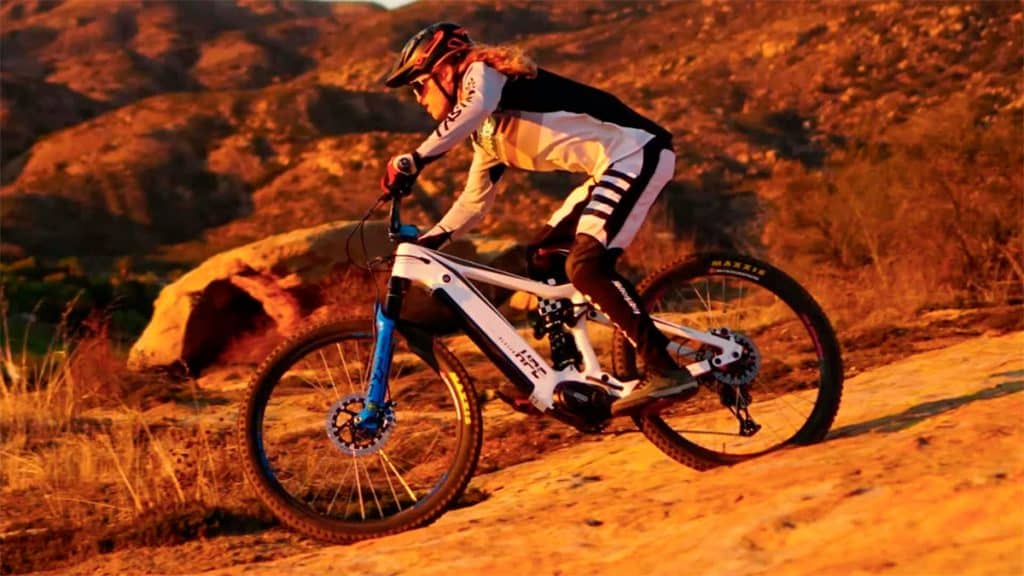 Homem andando na e-bike HPC Trailblazer numa trilha em dia ensolarado
