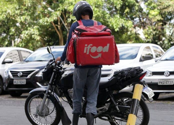 Entregador do Ifood de costas e com moto