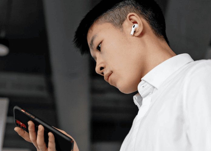 Imagem-mostrando-um-homem-com-o-Iphone-em-suas-maos-provavelmente-com-o-aplicativo-de-musica-funcionando-e-um-Airpod-Max-em-seus-ouvidos-695x500.png