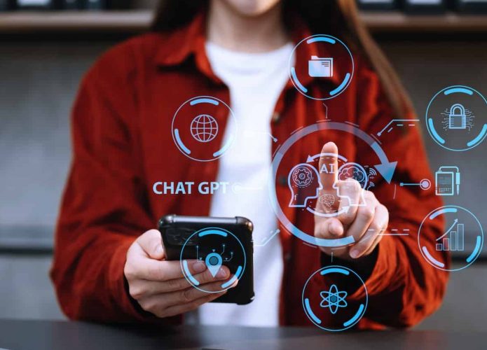 Mulher segurando celular com uma mão e tocando em holograma de IA com a outra