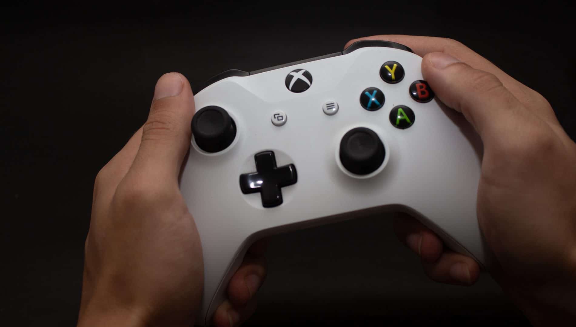 Mãos segurando o controle do Xbox One S da Microsoft