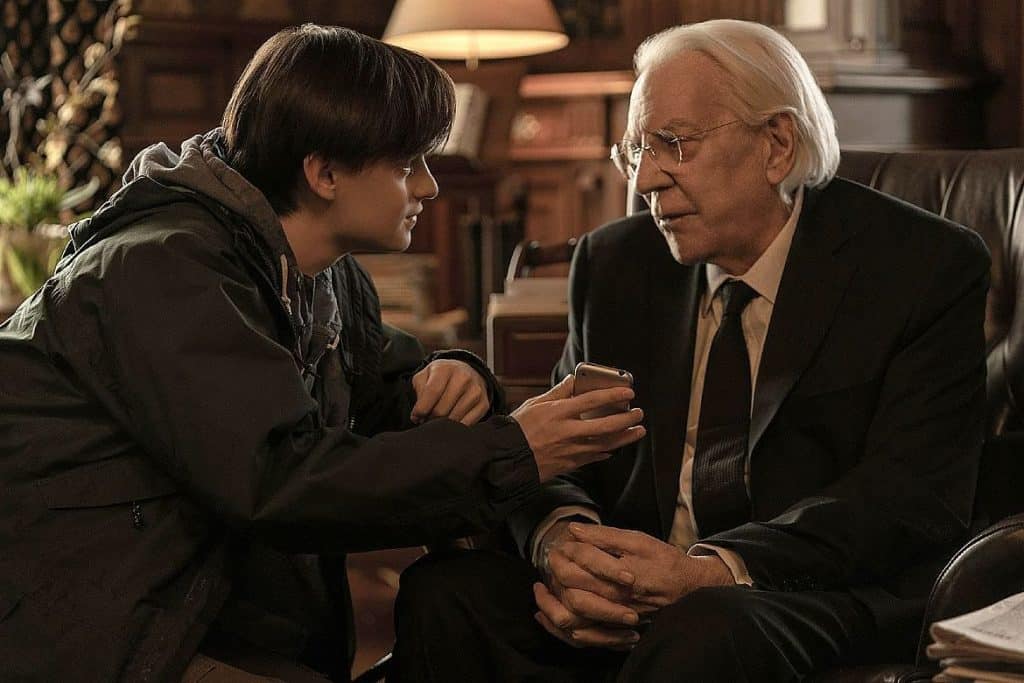 Imagem de garoto adolescente (ator Jaeden Martell) mostrando celular para idoso (ator Donald Sutherland) em cena do filme Mr. Harrigan's Phone