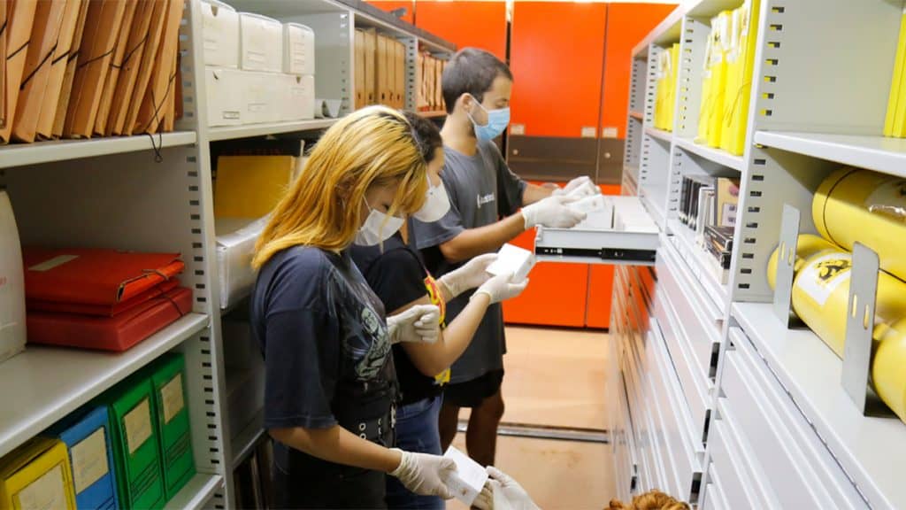 Alunos com bolsas de estudo realizando pesquisa em biblioteca