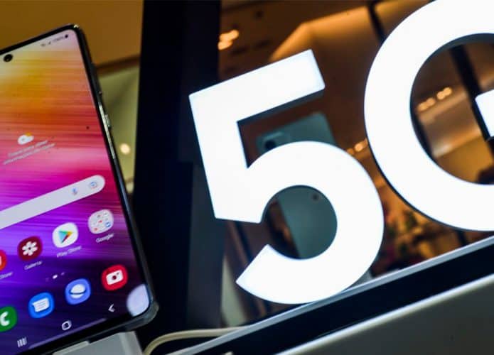 Celular em loja com letreiro de 5G ao lado