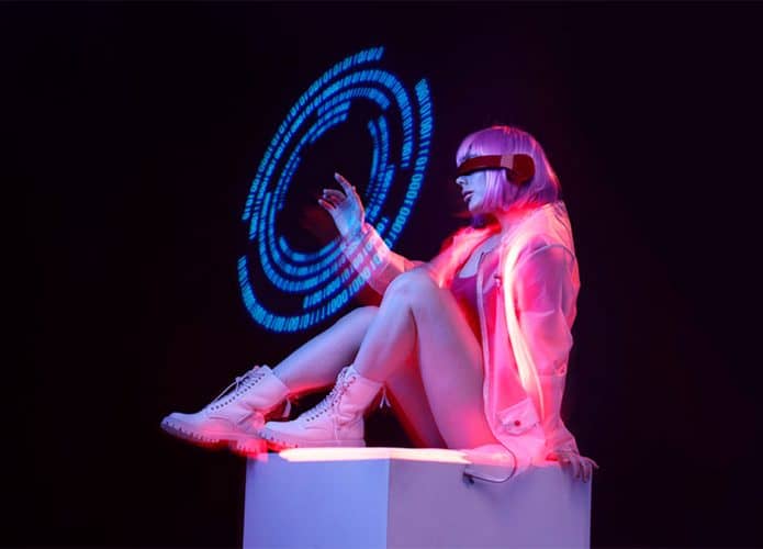 Mulher rosada vestindo roupa futurista interage com holograma