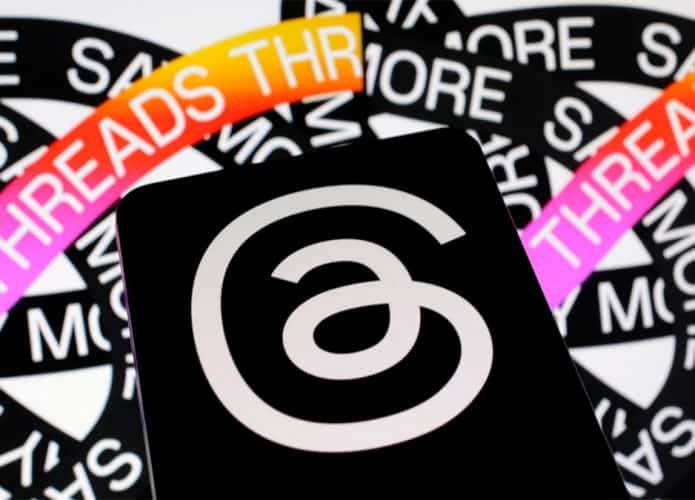 Celular com logomarca do Threads e, ao fundo, imagem da nova rede social da Meta