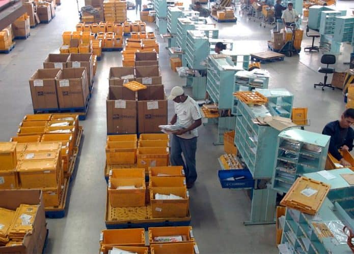 Visão de cima de funcionários trabalhando em galpão logístico