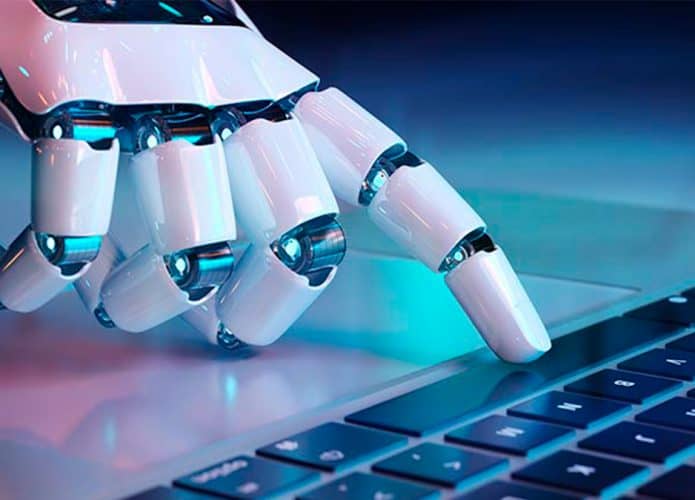 Mão robótica pressionando tecla de notebook