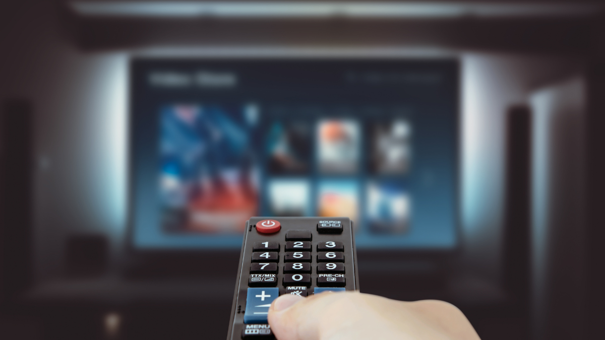 Imagem mostrando usuário com o controle da Smart Tv na mão .