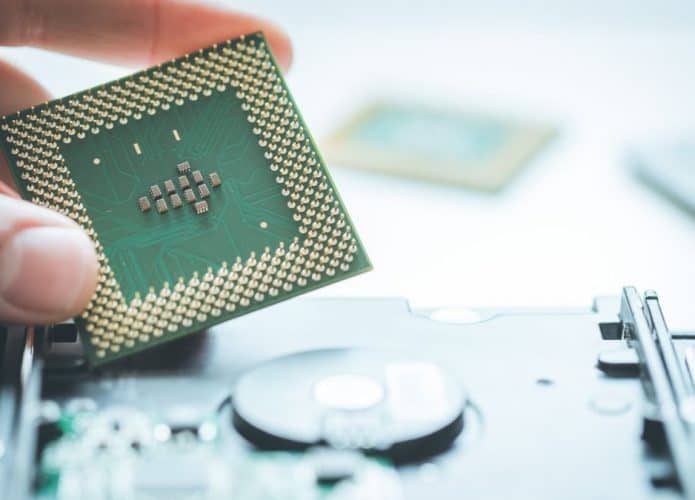 Pessoa segurando uma placa parecida com algum hardware de algum microcomputador