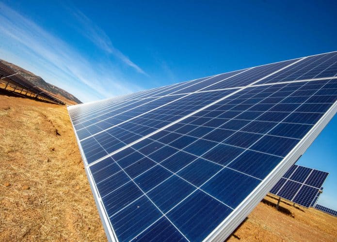 Imagem mostra paineis de energia solar com luz do sol refletindo neles