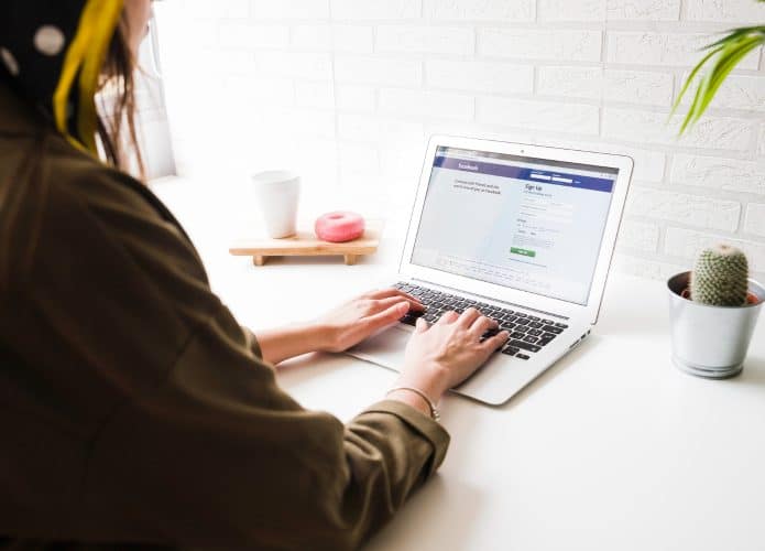 mulher-de-login-no-site-do-facebook-no-laptop-695x500