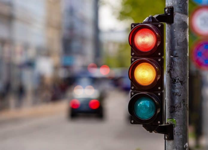 cruzamento da cidade com um semáforo, luz vermelha e laranja no semáforo, controle de tráfego