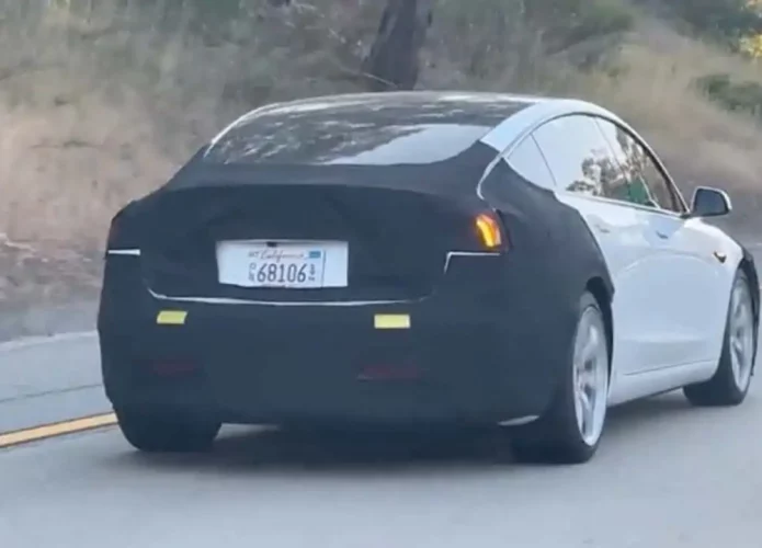 Novo modelo do Tesla Model 3 dirigindo em uma rodovia.