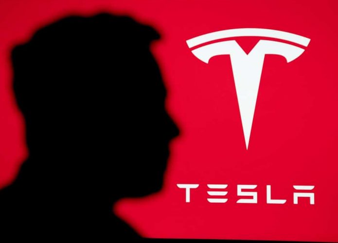 Silhueta do Elon Musk com logotipo da Tesla ao fundo