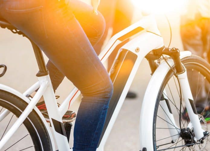 Pessoa andando em e-bike durante dia ensolarado