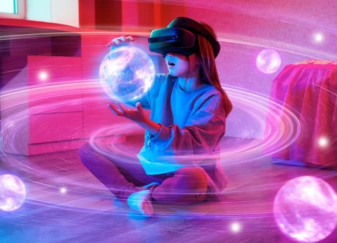 Menina nova usando óculos de realidade virtual e sentada brincando com hologramas de planetas