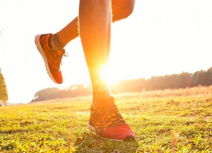 Pessoa caminhando de tênis com palmilhas Climfeet durante pôr do sol