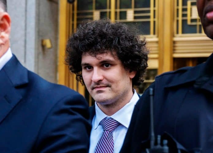 Sam Bankman-Fried, fundador da FTX, sendo conduzido por seguranças