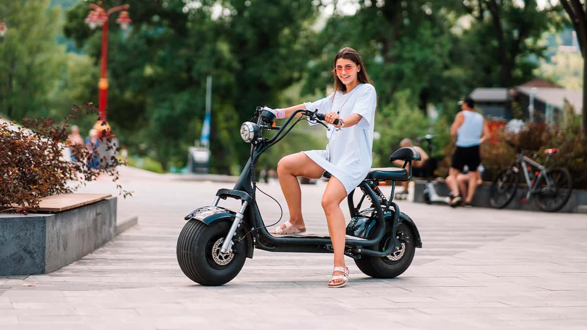 Moça em scooter, um dos veículos motorizados elétricos disponíveis no mercado
