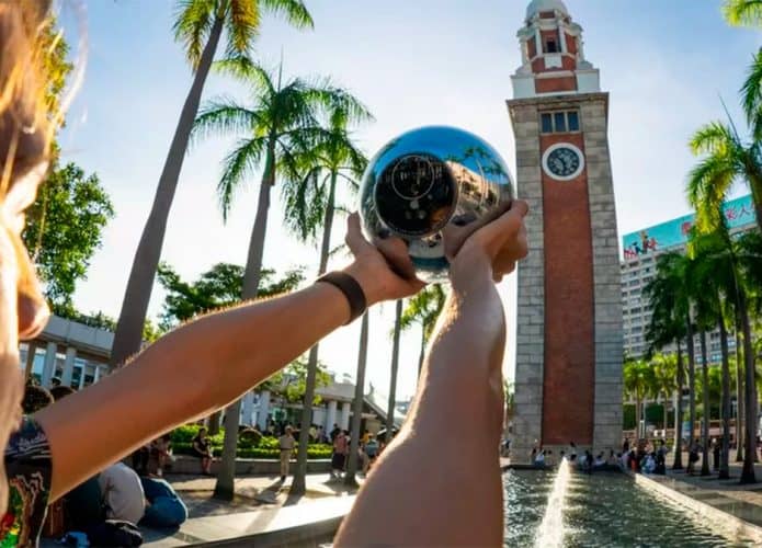 Pessoa segurando orbe da Worldcoin enquanto tem seus olhos escaneados
