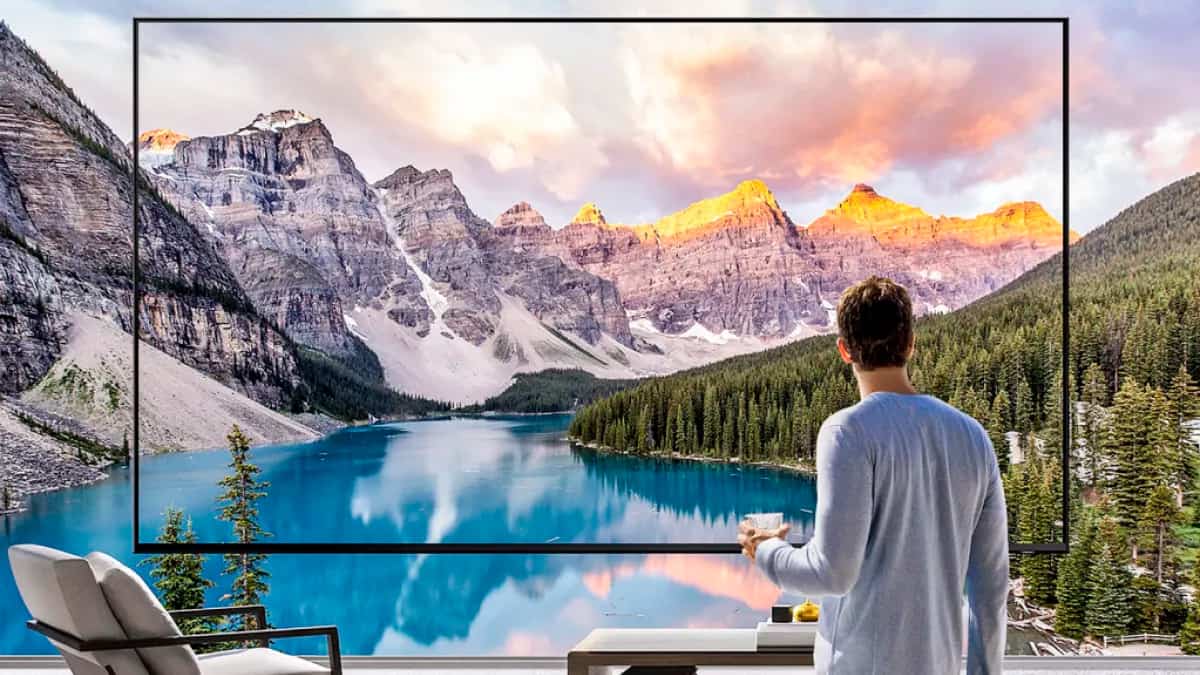 Montagem de homem segurando caneca olhando para super TV da Samsung