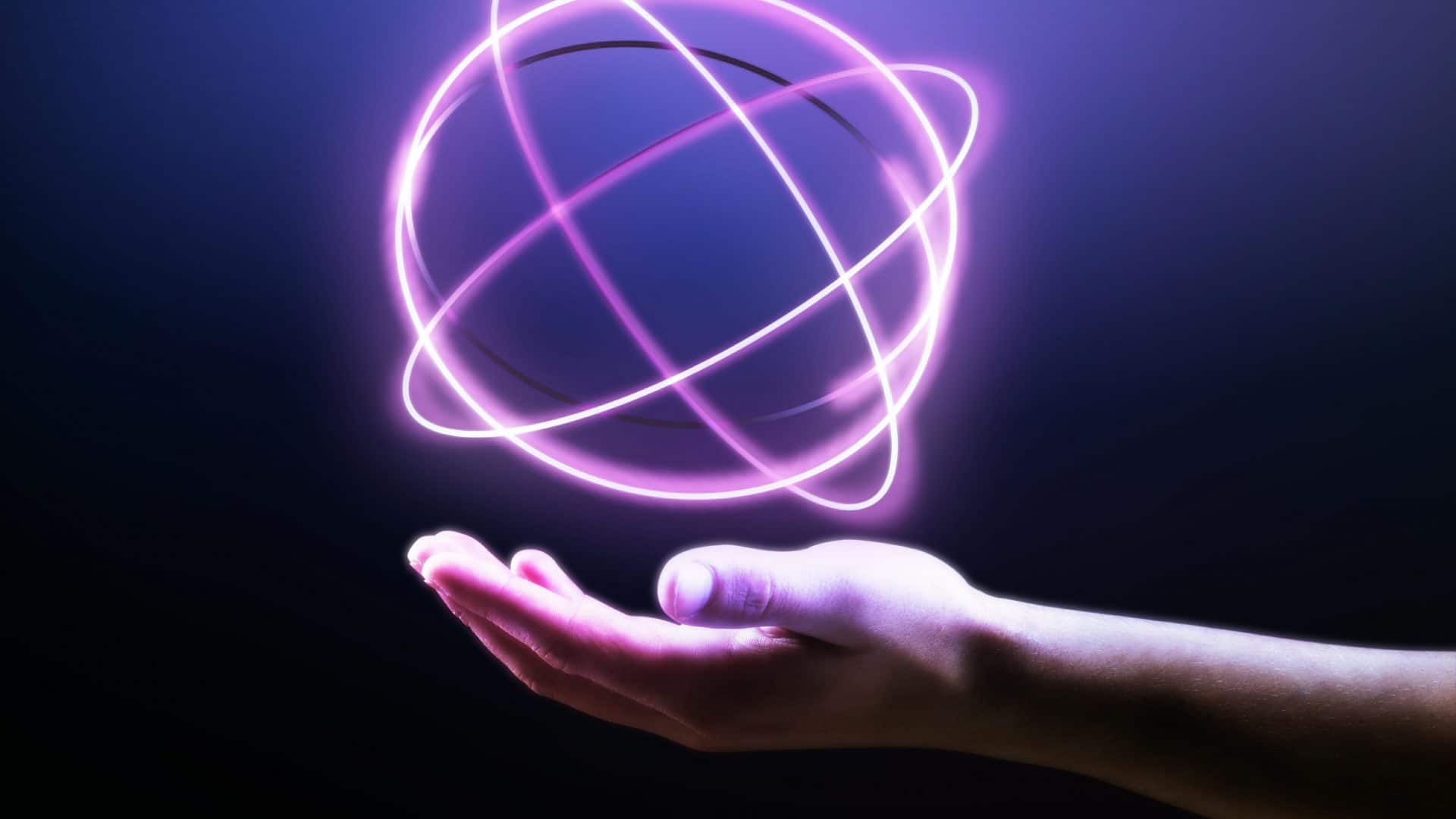 mão de uma pessoa mostrando um holograma de átomo